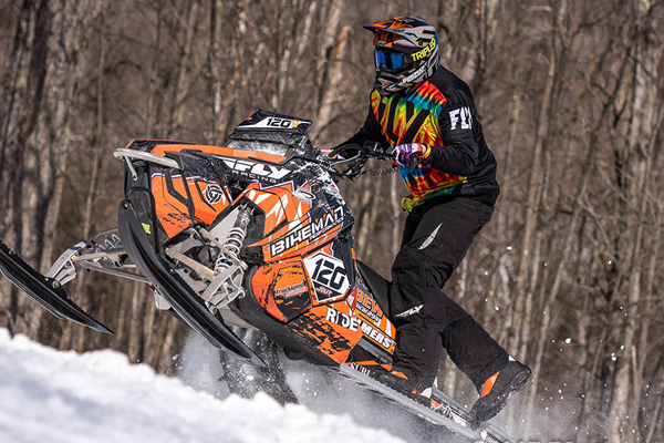 Racers competing in a snowmobile hillclimb challenge in Michigan, Wisconsin, Minnesota, Iowa