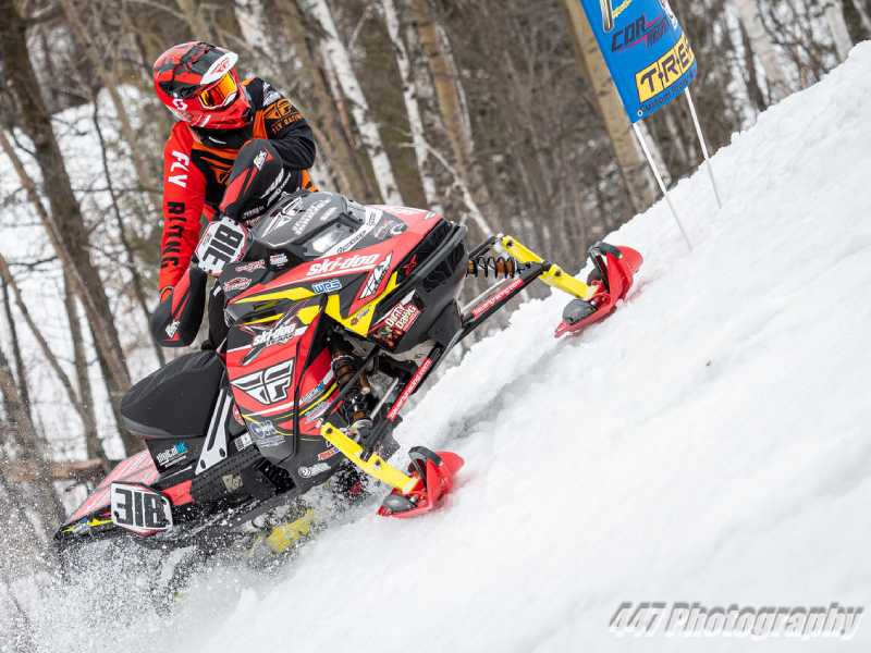 Snowmobile racer jumping a hillcross circuit in Michigan, Wisconsin, Minnesota, Iowa