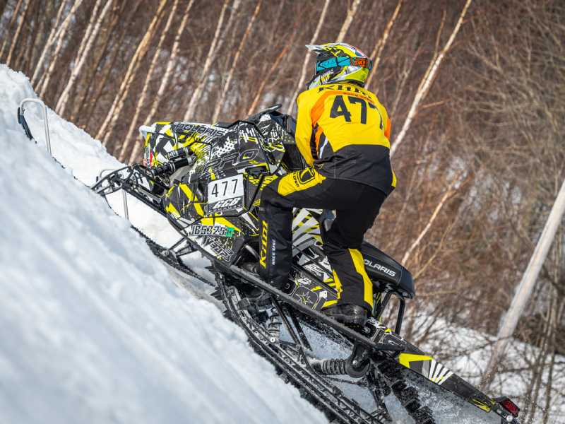 Two snowmobile drivers jumping a hill during a race in Michigan, Wisconsin, Minnesota, Iowa